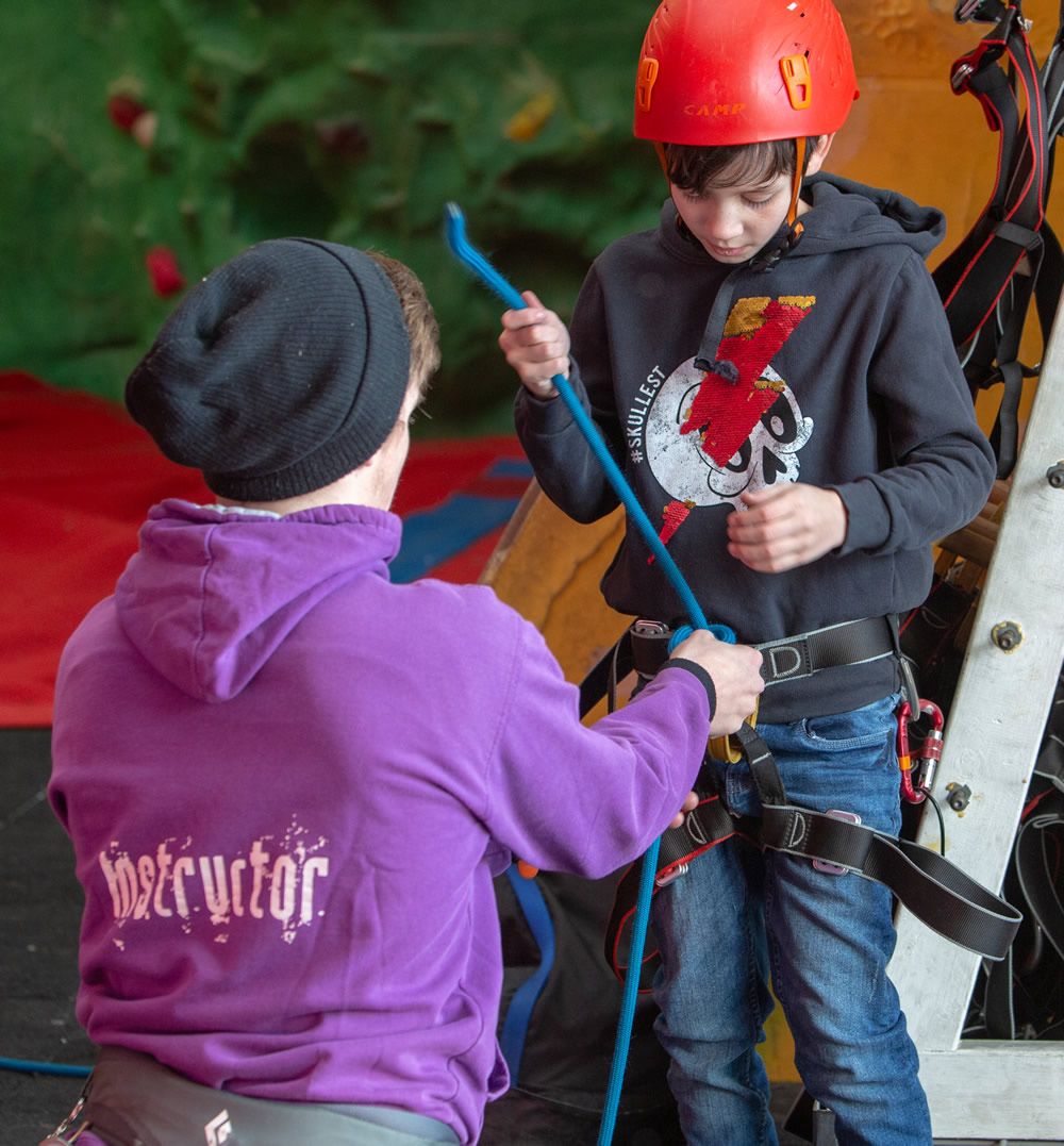 young person preparing harness to climb
